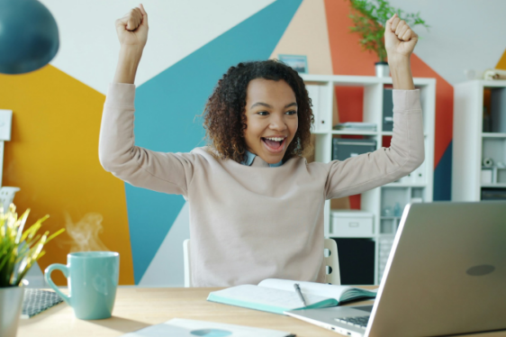 happy woman at laptop, colourful studio