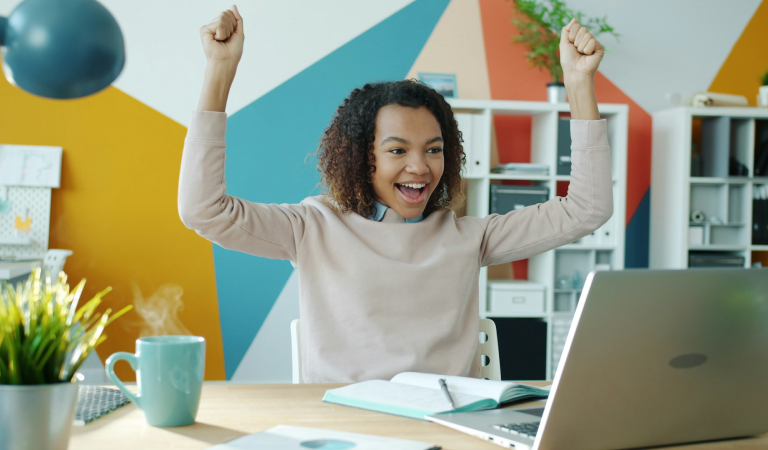 happy woman at laptop, colourful studio