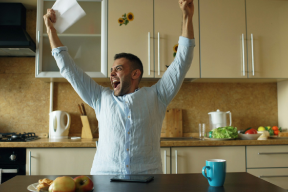 man celebrating happy news at home
