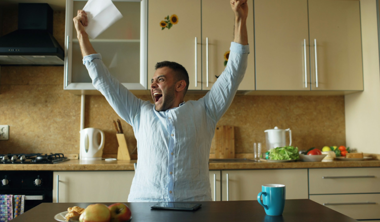 man celebrating happy news at home