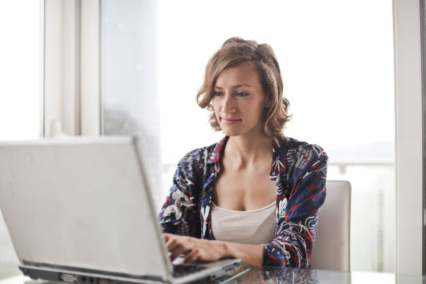 woman at glass table with laptop