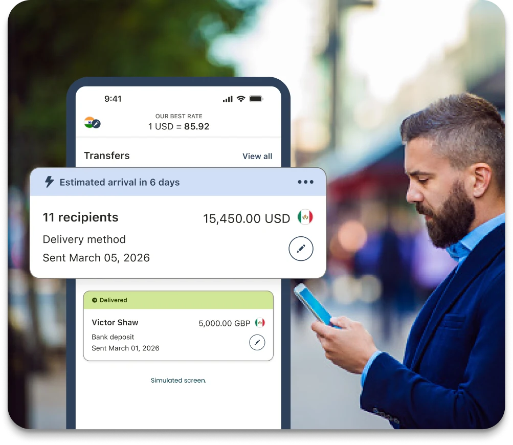 Business owner checking a phone showing a transfers list with a bulk payment to 11 recipients