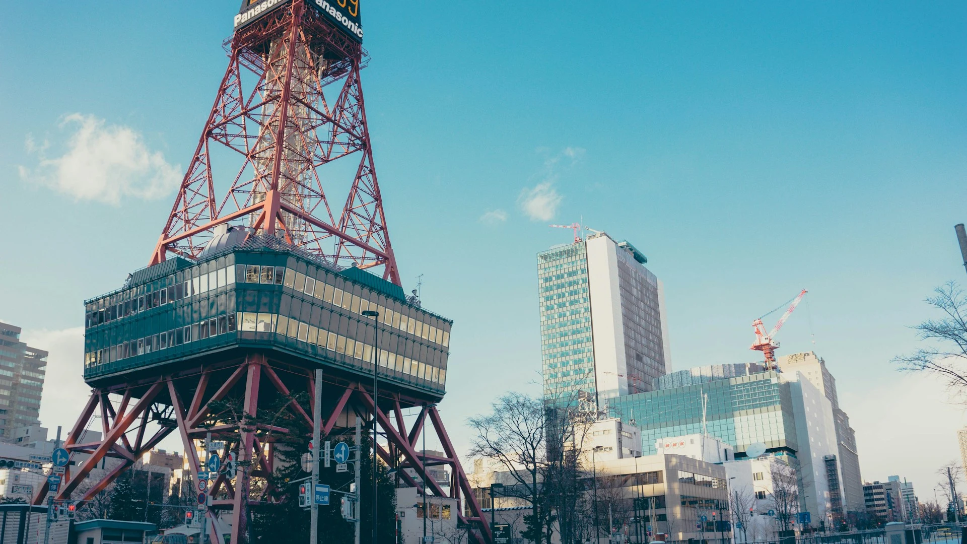 Sapporo TV Tower and city buildings under a clear blue sky.
