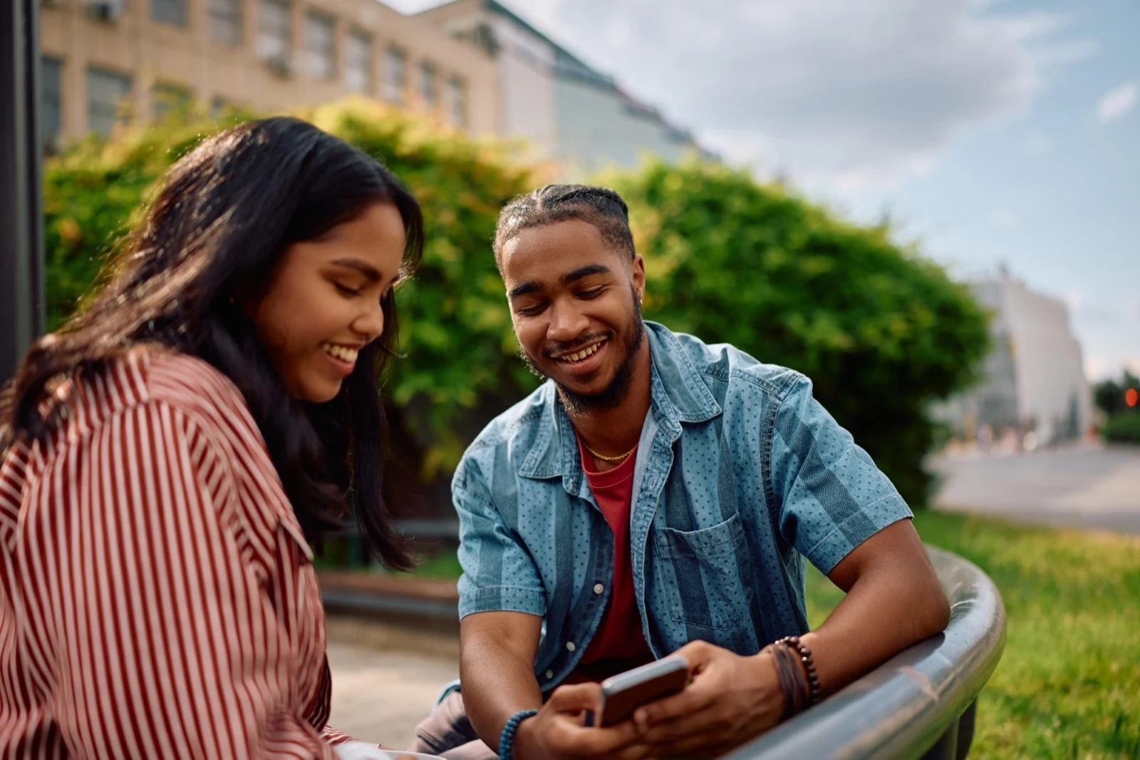 Two students looking at a phone on campus