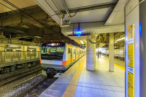 Train arriving at a platform in a Tokyo railway station.
