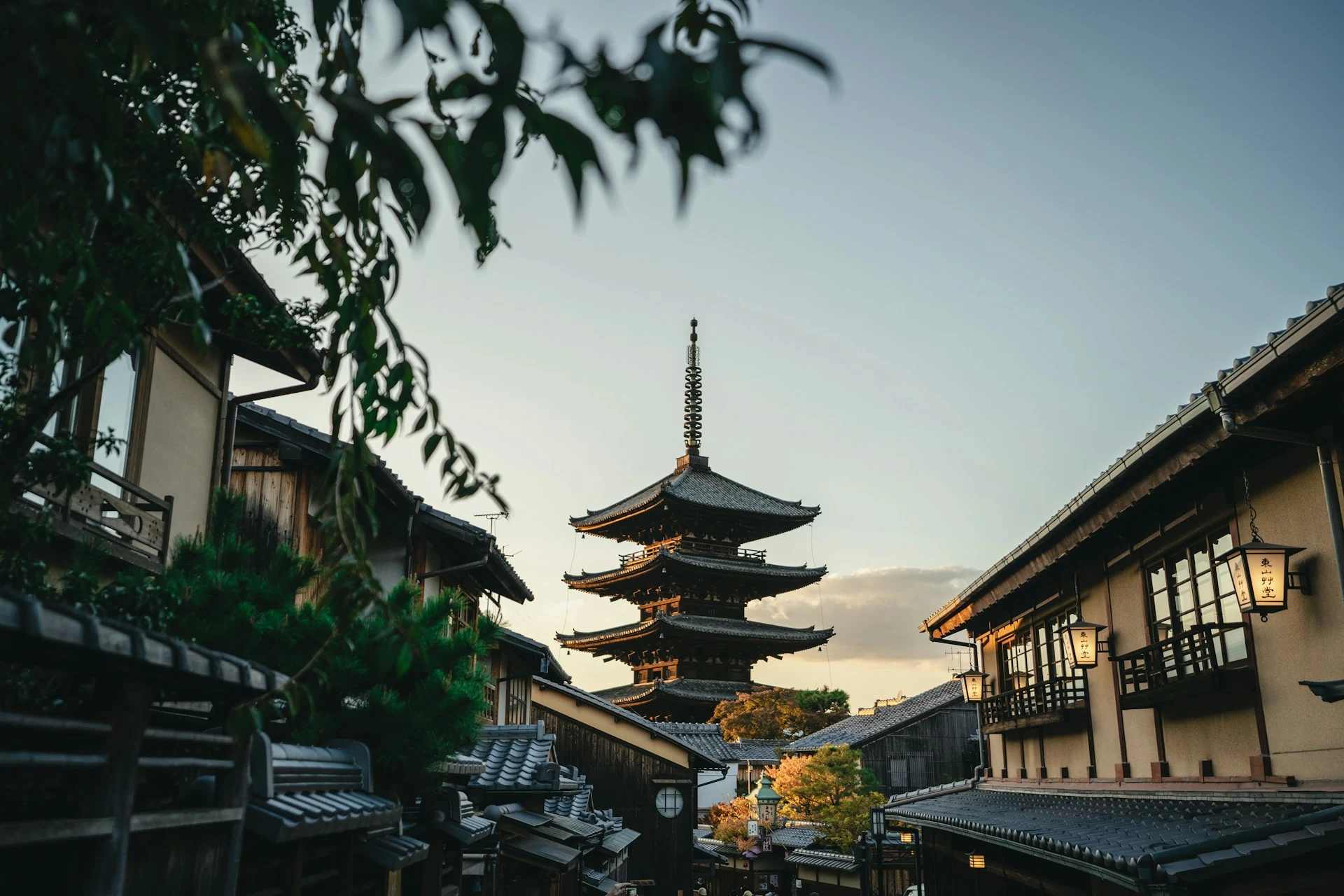 Yasaka Pagoda rising above traditional wooden houses in Kyoto at sunset.