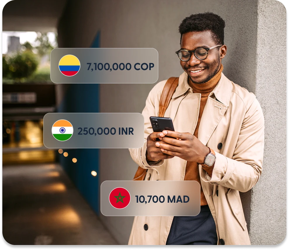Business owner on a phone, beside amounts a recipient could receive in Colombian pesos, Indian rupees and Moroccan dirhams