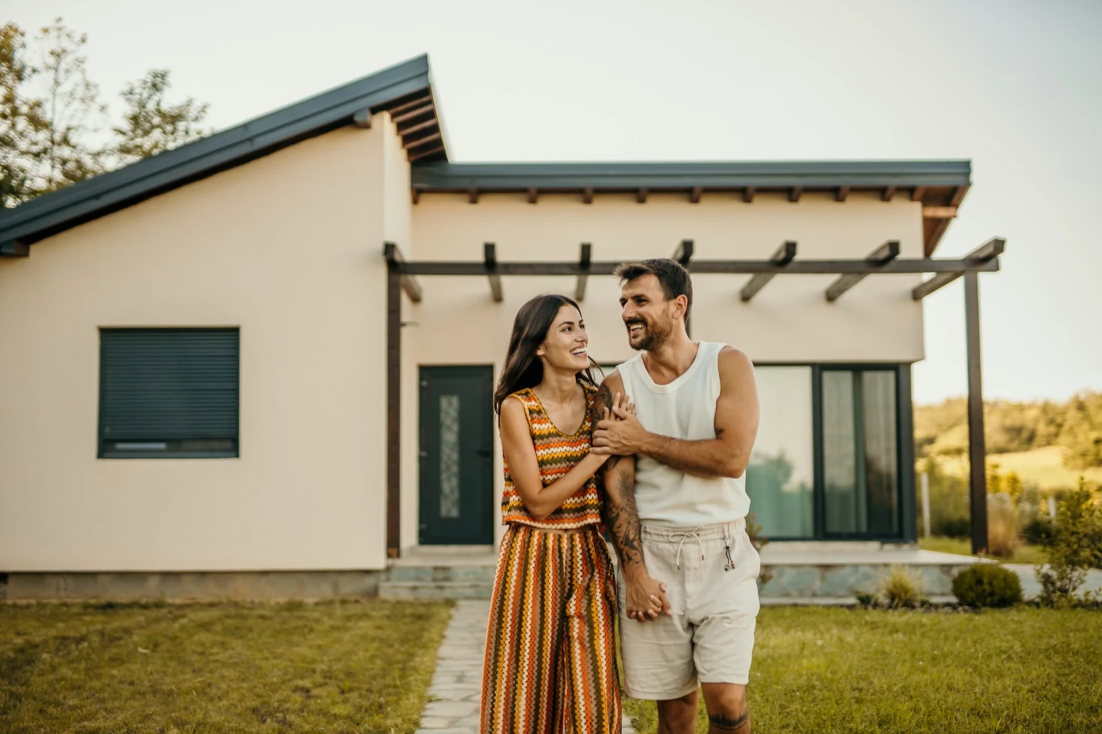 Couple standing in front of their new home