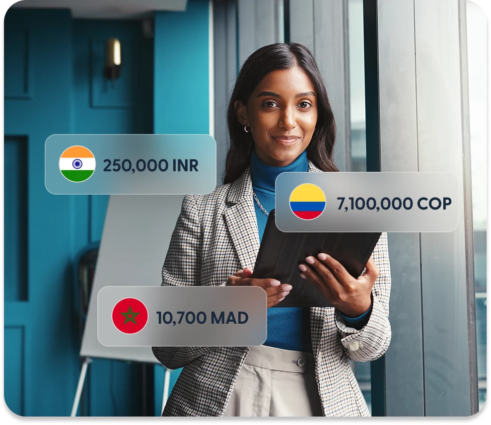 Business owner with a tablet, beside amounts a recipient could receive in Indian rupees, Colombian pesos and Moroccan dirhams