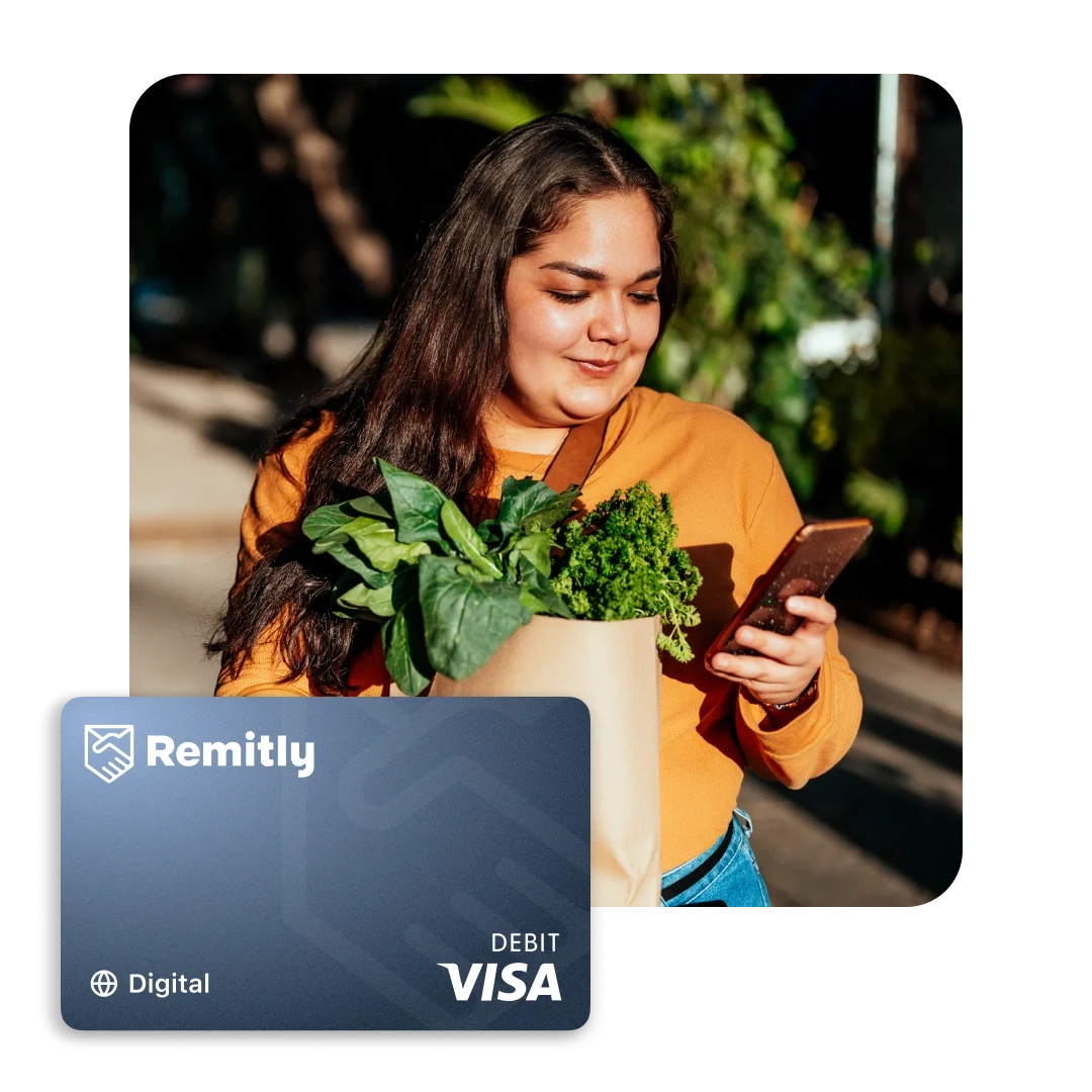 Person holding groceries while checking a phone with a Remitly Card.